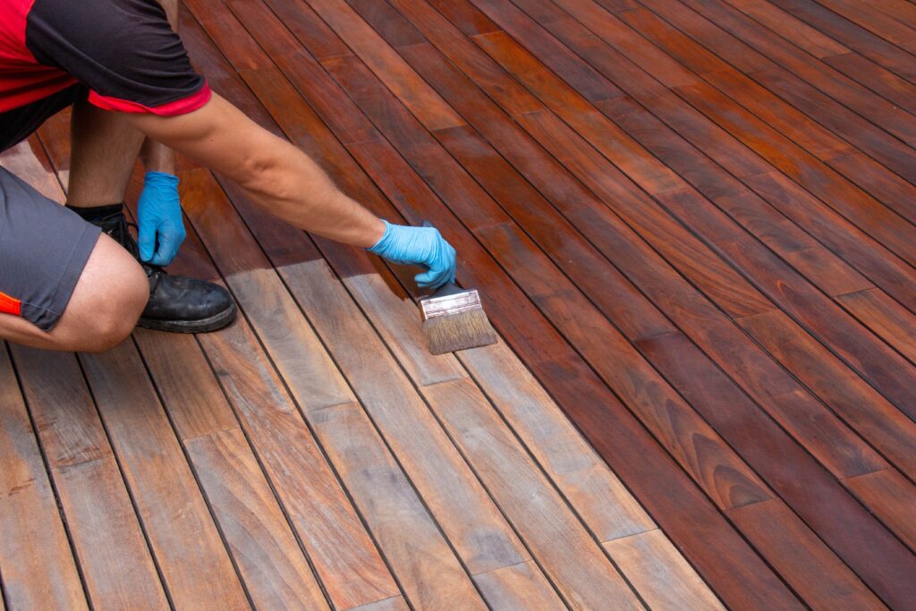 Worker,Applying,Terrace,Oil,With,A,Brush,,Wood,Decking,Renovation